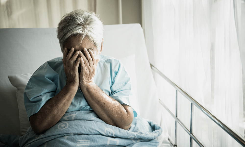 an elderly woman in bed crying